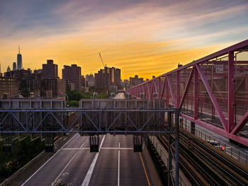 Bridge in city against sky during sunset