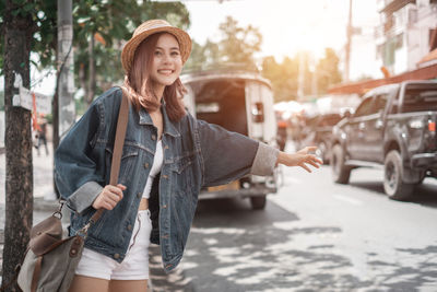 Young woman standing on street in city