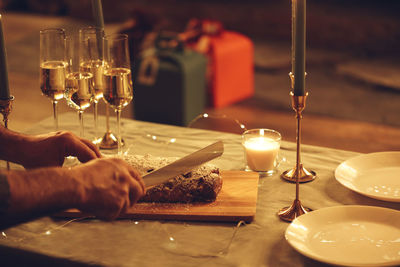 Cropped hand of woman holding wineglass on table