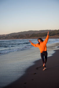 A woman dances at sunset along the coast