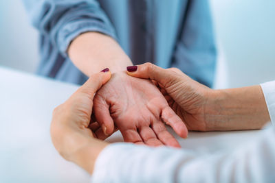 Examining the hand of a senior patient with carpal tunnel syndrome. 