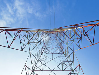 View of high voltage tower form inside in blue sky
