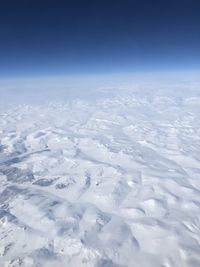 Aerial view of snowcapped landscape against sky