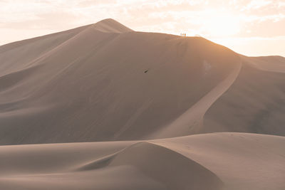 Sand dunes in desert against sky