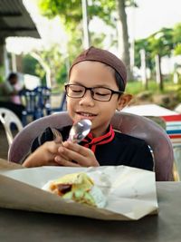 Portrait of boy eating food in restaurant