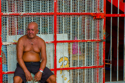 Portrait of shirtless man sitting outdoors