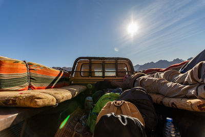 People on car against blue sky on sunny day