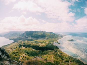 Scenic view of landscape by sea against sky