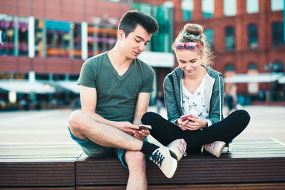 Young couple sitting on bridge in city