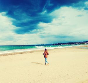 Full length of woman on beach against sky