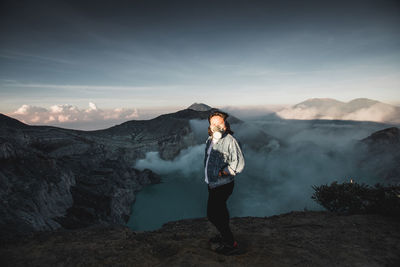 Full length portrait of woman standing on mountain