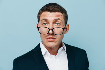 Portrait of businessman wearing eyeglasses against white background