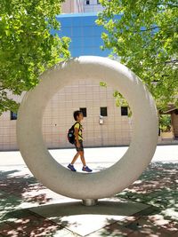 Low angle view of girl standing by tree