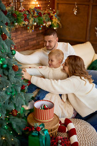 High angle view of cute girl playing with christmas tree at home