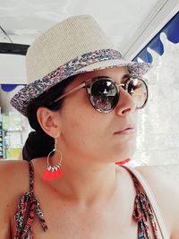 Close-up of fashionable woman wearing hat and sunglasses