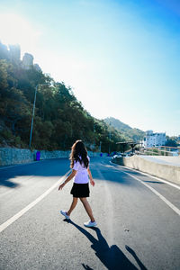 Rear view of woman running on road