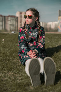 Young woman wearing sunglasses sitting outdoors