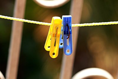 Close-up of clothespins hanging on rope