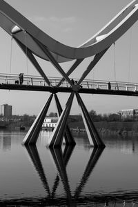 Bridge over river in city against sky