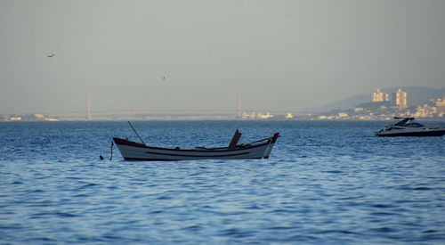 Fishing boat in sea against clear sky