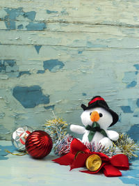 Snowman toy with ornaments on table during christmas