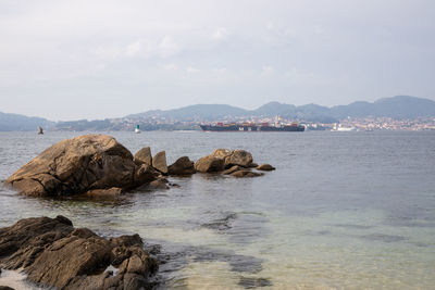 Rocks on sea shore against sky