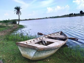 Boat moored on shore against sky