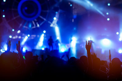 Crowd with arms raised enjoying at music concert