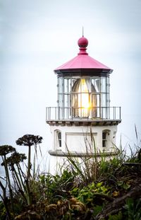 Lighthouse by sea against sky