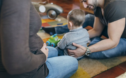 Parents playing with son while sitting at home