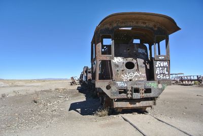 Abandoned truck on field against clear sky