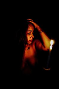 Portrait of young woman against black background