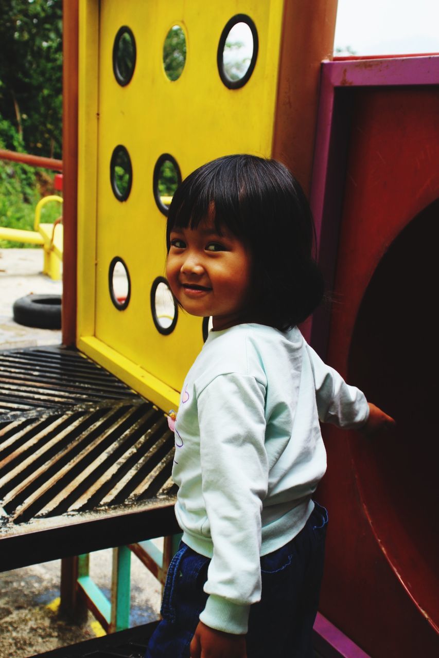 childhood, child, real people, boys, casual clothing, one person, happiness, smiling, cute, lifestyles, innocence, males, seat, females, portrait, leisure activity, standing, three quarter length, hairstyle, bangs