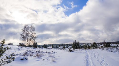 Scenic view of snow covered land against sky