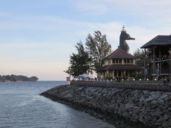 Statue of building by sea against sky