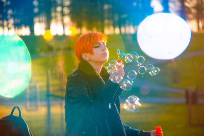 Side view of woman looking at bubbles
