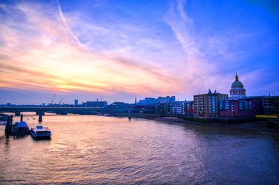 Scenic view of sea against buildings during sunset