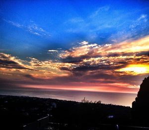 Scenic view of dramatic sky over sea during sunset