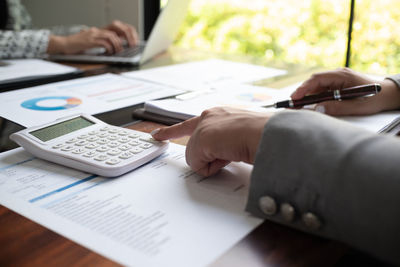 Midsection of businessman working on table