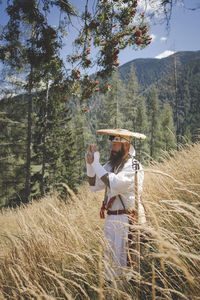 Man standing by tree on field