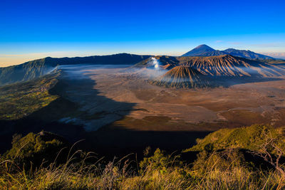 Panoramic view of volcanic landscape against blue sky