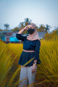 Woman standing on field against sky