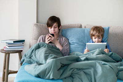 Friends relaxing on bed at home