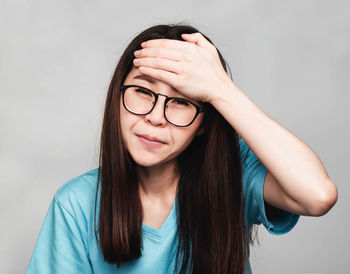 Portrait of beautiful young woman against white background