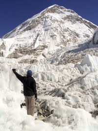 Rear view of man standing on snow covered land