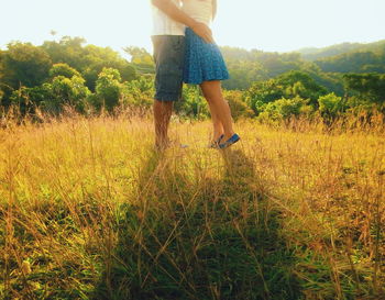 Low section of woman standing on field