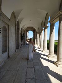 Rear view of woman walking in corridor of building