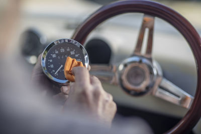 Senior man polishing tachometer of a car