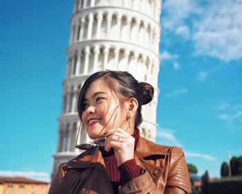 Low angle view of young woman against the sky