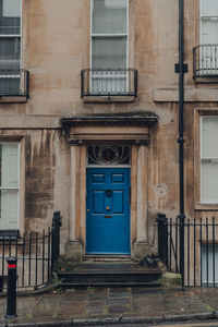 Bright blue front door on a traditional limestone terraced house in bath, somerset, uk.
